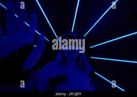Woman is using virtual reality headset to access in metaverse. Concept of virtual, augmented and extended reality, future technology, artificial intel Stock Photo
