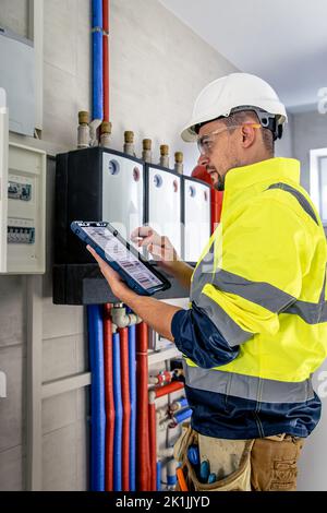 Electrical technician looking focused while working in a switchboard with fuses. Stock Photo