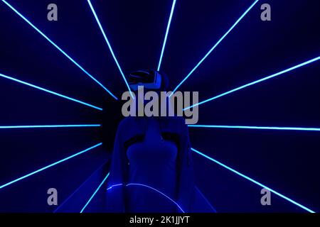 Woman is using virtual reality headset to access in metaverse. Concept of virtual, augmented and extended reality, future technology, artificial intel Stock Photo