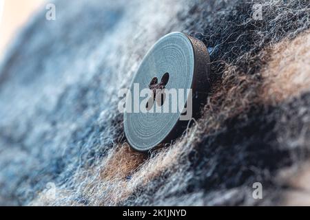 Button on a warm blue shirt, macro shot. Stock Photo