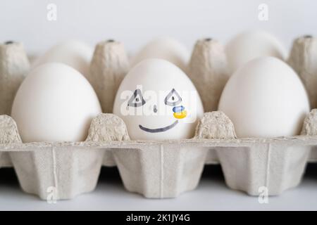 Painted egg with facial expression and ukrainian flag on white background Stock Photo