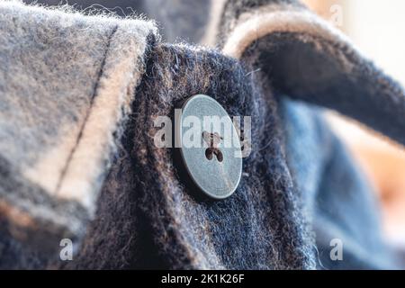 Button on a warm blue shirt, macro shot. Stock Photo
