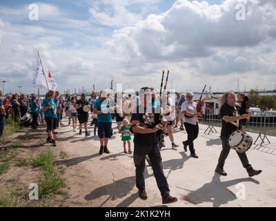Doel, Belgium, 21 August 2022, Street musicians with bagpipes and drums followed by a man carrying a flag Stock Photo
