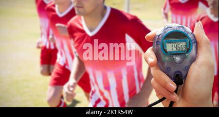 Composite image of close up of a hand holding a timer on a white background Stock Photo