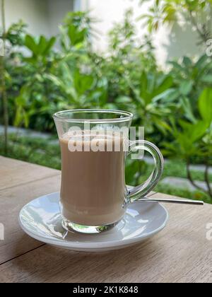 Glass cup with milk tea. Selective focus on the glass cup. Stock Photo