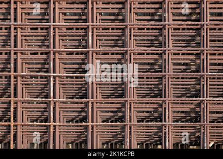 Reinforcing iron mesh stacked on top of each other and forming a pleasing symmetrical pattern, industrial background idea with metal rods fabric Stock Photo