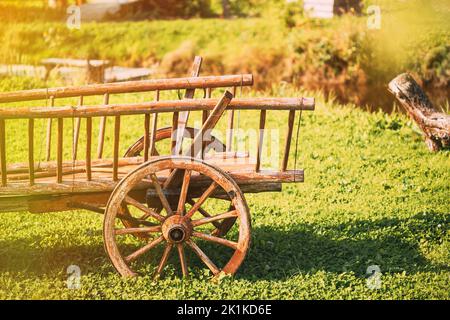 Decorative Peasant Cart On Summer Lawn. Bright Sunny Day. Garden Decoration Concept. Gardening And Housekeeping. Vintage Cart On Summer Sunny Day Stock Photo