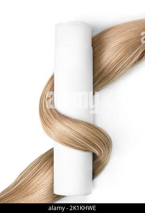 A strand of blond hair with a bottle of shampoo on a white background. Close-up. Stock Photo