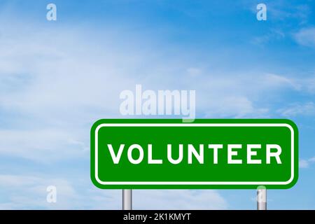 Green color transportation sign with word volunteer on blue sky with white cloud background Stock Photo