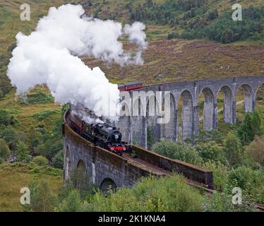 Glenfinnan, Scotland, UK, 19th September 2022. Floral tribute to Her Majesty Queen Elizabeth 11 displayed on front of Jacobite Steam Train engine as it is passes over the west highland line Glenfinnan Viaduct just before her funeral service at Westminster Abbey in London. Credit: Arch White/alamy live news. Stock Photo
