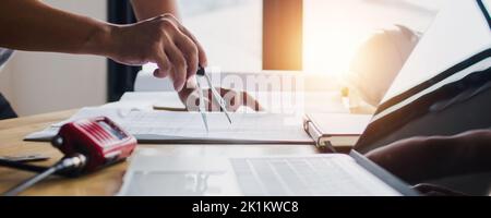 Close up hand of architect use drawing compass on blue print on table Stock Photo