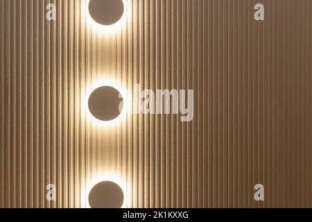 Three warm lights in the dark in a striped white wall as decoration and lighting Stock Photo