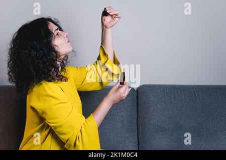 Adult woman using and holding medical cannabis oil. CBD. Concept of herbal and alternative medicine Stock Photo