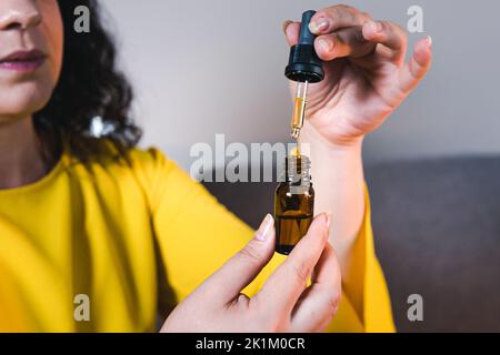 Adult woman using and holding medical cannabis oil. CBD. Concept of herbal and alternative medicine Stock Photo
