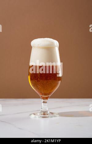One glass amber golden beer overflowing food and drink Stock Photo