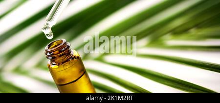 essential oil drop falling from dropper into the bottle. natural bio cosmetics, alternative medicine. banner with copy space Stock Photo
