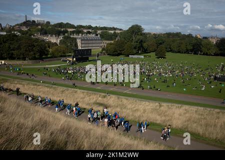 Edinburgh Scotland, 19 September 2022. In Holyrood Park, in front of the Royal family’s Palace of Holyroodhouse, crowds watch on a large screen the funeral in London of Her Majesty Queen Elizabeth II who died on 8th September, in Edinburgh Scotland, 19 September 2022. Photo credit: Jeremy Sutton-Hibbert/Alamy Live News. Stock Photo