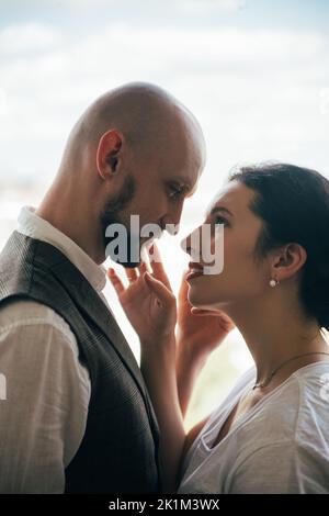 Romantic couple. Family photo. Trustful love. Happy together. Beloved man and woman looking sensually each other isolated on white side view. Stock Photo