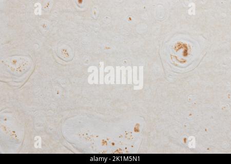 fragment of flour tortilla close-up, background of pita bread, wheat round tortilla or pita lavash round flat bread Stock Photo