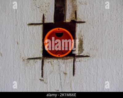 Plastic backbox for socket or switch inserted into the drilled hole on the wall Stock Photo