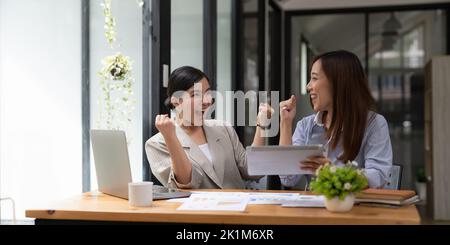 Business asian smile and raise hands up, feeling happy, complete finish job, teamwork successful achievement working in office concept Stock Photo