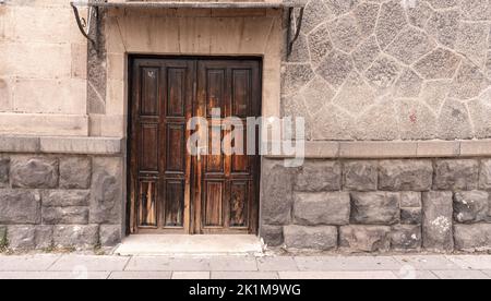 Old classical stone house with rustic, brown, carved, vintage wooden door. Door textures and backgound. High quality photo. Stock Photo