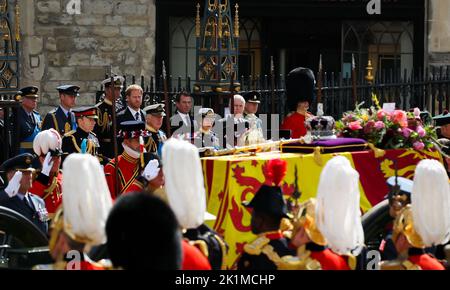 London, UK. 19th Sep, 2022. 19 September 2022, Great Britain, London: Prince William (2nd from left), Prince of Wales, Prince Harry (4th from left), Duke of Sussex, King Charles III (5th from left), Princess Anne (4th from right), Prince Andrew (3rd from right), Duke of York, Prince Edward (2nd from right), Earl of Wessex, stand behind the coffin after the act of state before the funeral of Queen Elizabeth II in front of Westminster Abbey. Hundreds of thousands of people are expected on the streets of London for the state funeral for Elizabeth II. Presidents, heads of government and crowned he Stock Photo