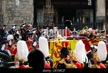 London, UK. 19th Sep, 2022. 19 September 2022, Great Britain, London: Prince William (2nd from left), Prince of Wales, Prince Harry (4th from left), Duke of Sussex, King Charles III (5th from left), Princess Anne (4th from right), Prince Andrew (3rd from right), Duke of York, Prince Edward (2nd from right), Earl of Wessex, stand behind the coffin after the act of state before the funeral of Queen Elizabeth II in front of Westminster Abbey. Hundreds of thousands of people are expected on the streets of London for the state funeral for Elizabeth II. Presidents, heads of government and crowned he Stock Photo