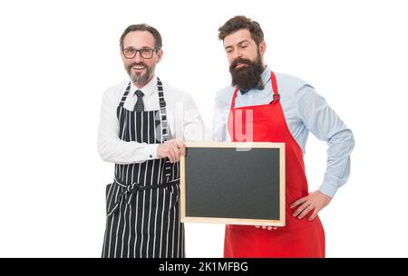 Hiring staff. Men bearded hipster informing you. Men bearded bartender or cook in apron hold blank chalkboard. Workers wanted. Bartender with Stock Photo