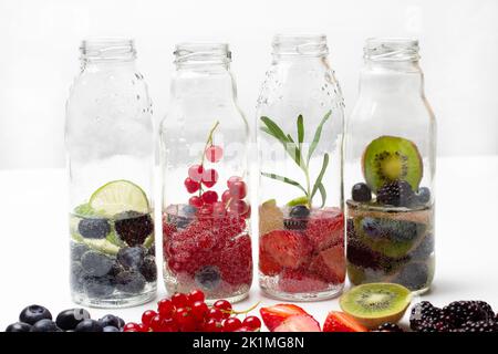 Sparkling berries water in glass bottles. Close up. White background Stock Photo