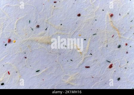 Straw paper texture background made from recycled sustainable biodegradable resources with a natural white yellow, green, blue and red textured artifa Stock Photo