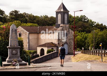 Pilgrim near the Church of Saint-Pierre, Argagnon along the route of Chemin du Puy in the canton of Arthez-de-Béarn. Pyrénées-Atlantiques, France Stock Photo