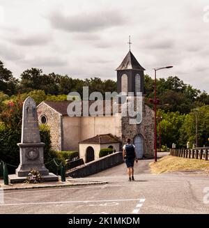 Pilgrim near the Church of Saint-Pierre, Argagnon along the route of Chemin du Puy in the canton of Arthez-de-Béarn. Pyrénées-Atlantiques, France Stock Photo