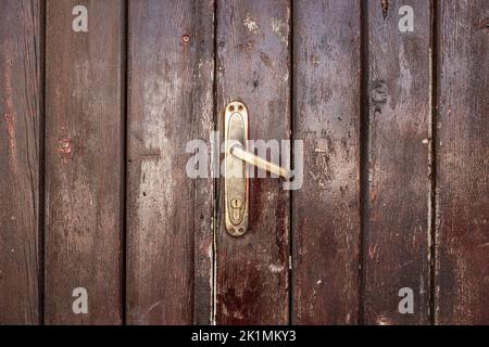 Old, faded classical, brown, wooden door with iron door handle. Door ...