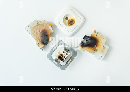 Electrical short circuit. Failure caused by burning wire and rosettes socket plug in house Stock Photo
