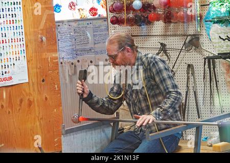 A glass blowing artist and craftsman creats a jar in a glass blowing studio in the small town of Seal Rock, Oregon. Stock Photo