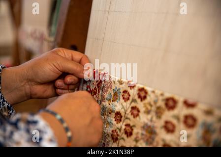 Carpet weaving using traditional techniques on a loom. , close-up of weaving and handmade carpet production. Stock Photo