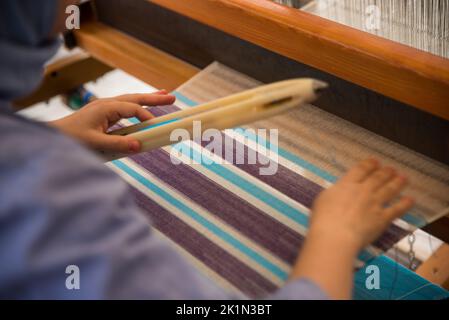 Carpet weaving using traditional techniques on a loom. , close-up of weaving and handmade carpet production. Stock Photo