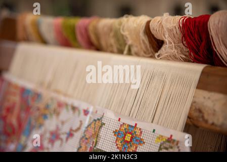 Carpet weaving using traditional techniques on a loom. , close-up of weaving and handmade carpet production. Stock Photo