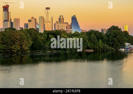 The Austin TX Skyline as the sunsets over the Colorado River in the Fall on the River from the Ann and Roy Butler Hike and Bike Trail and Boardwalk Stock Photo