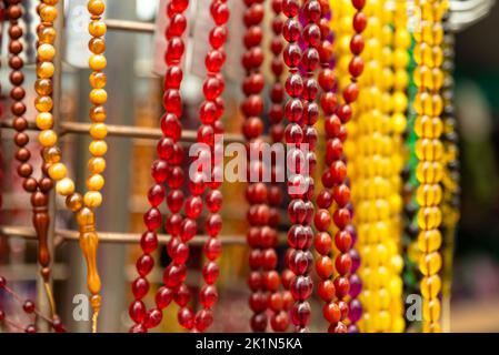 colorful rosaries in the sunlight, sales aisle Stock Photo