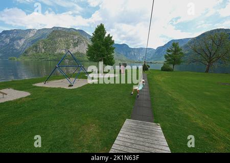 Boy swinging on rope at playground Hallstatt, Austria. Stock Photo