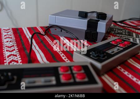 Retro gaming console with classic gamepad controller on a table Stock Photo