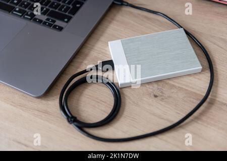 A external hard drive, file storage device connected to a laptop computer. Stock Photo