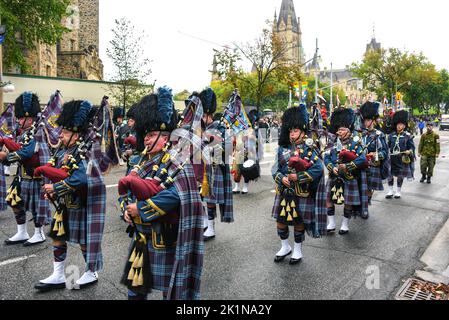 Ottawa, Canada - September 19, 2022: Marching band with bagpipers during a memorial parade on Wellington Street heading towards Christ Cathedral an Anglican church for a commemorative ceremony for the funeral of Queen Elizabeth II. The federal government declared the day a federal holiday and a national day of mourning for the Queen, with federal public servants having the day off. Stock Photo