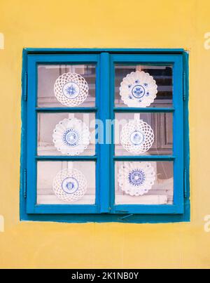 Ornamental traditional plates or dish on display in a old wooden window. Golden lane in Prague, Czech Republic. Stock Photo