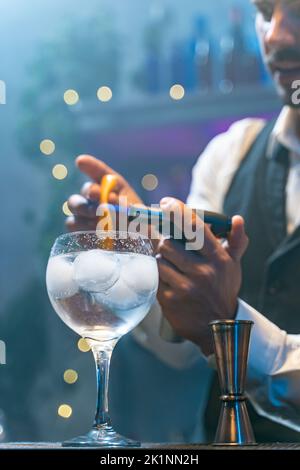 Professional barman making cocktail with fire at party in nightclub. Night life concept Stock Photo