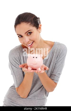 Theres a new pair of shoes in here somewhere. Studio shot of an attractive young woman holding a piggy bank. Stock Photo