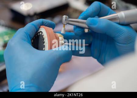Dental technician making dentures. Dental prosthesis, prosthetics work Stock Photo