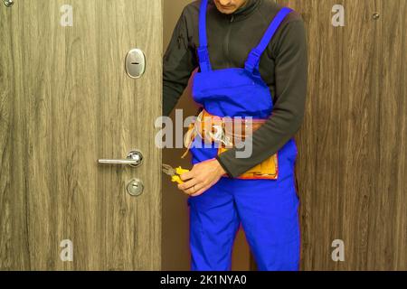 handyman repair the door lock in the room Stock Photo